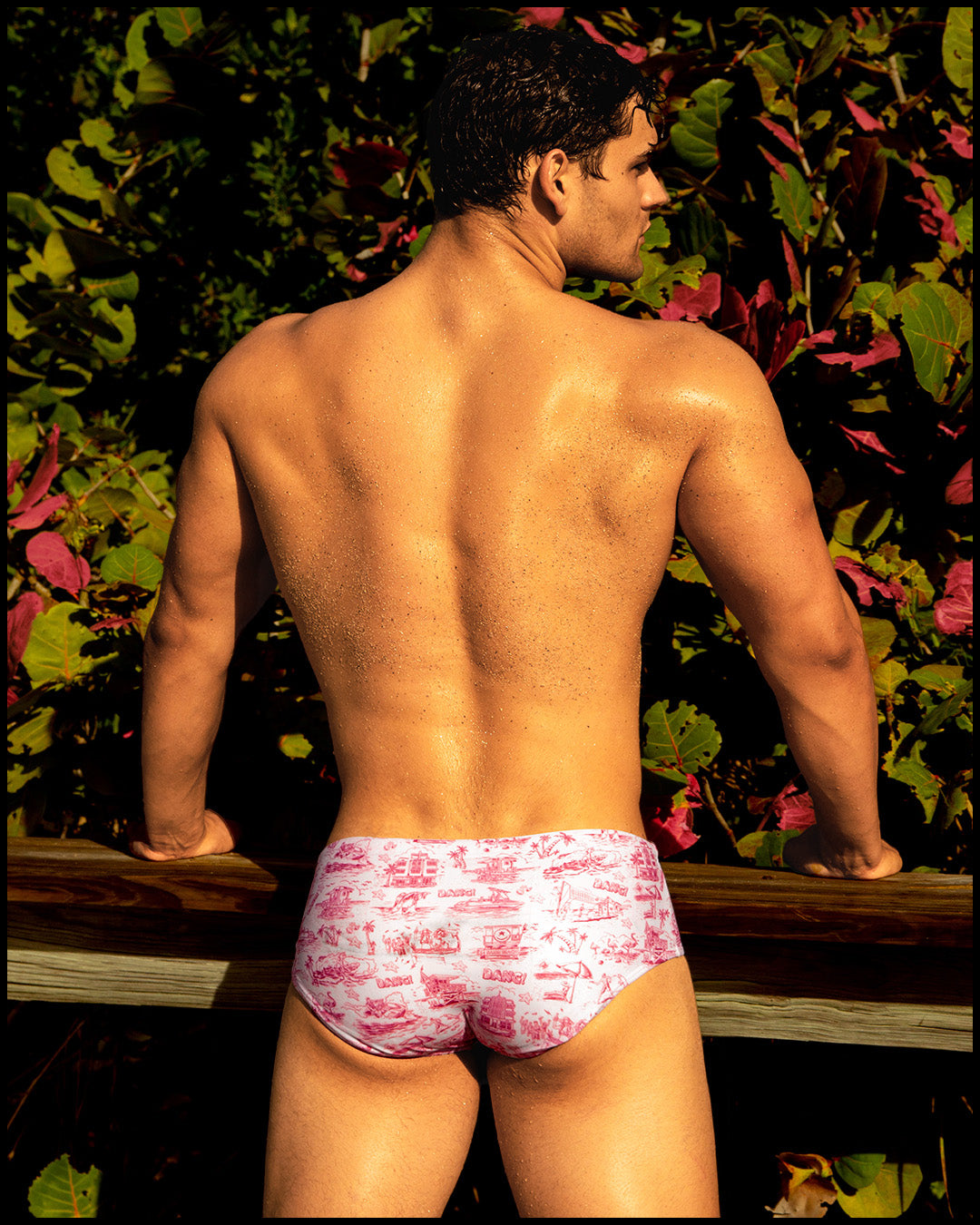Male model wearing the TOILE DE MIAMI (RED) Swim Sunga featuring a red and white toile de jouy print by BANG! Clothes the official brand of men’s swimwear brand based in Miami, FL.