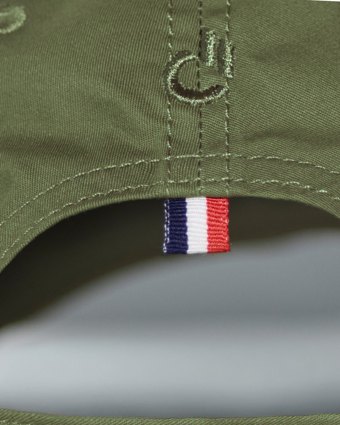 Back detail of the DC2 Resort Cap in Army Green — featuring tonal stitching and a woven tricolor accent tab.