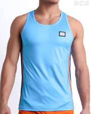 Male model wearing COASTAL BLUE men’s casual Tank Top. A premium quality top in a solid light blue color with orange and navy blue stripes on the sides, a men’s beachwear brand from Miami.