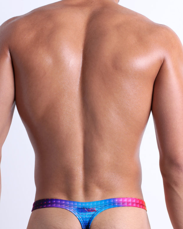 Back view of a model wearing CONFESSIONS ON A SAND FLR VOL 2 men’s beach swim thong featuring multiple colors disco ball print made by the Bang! Miami official brand of men&