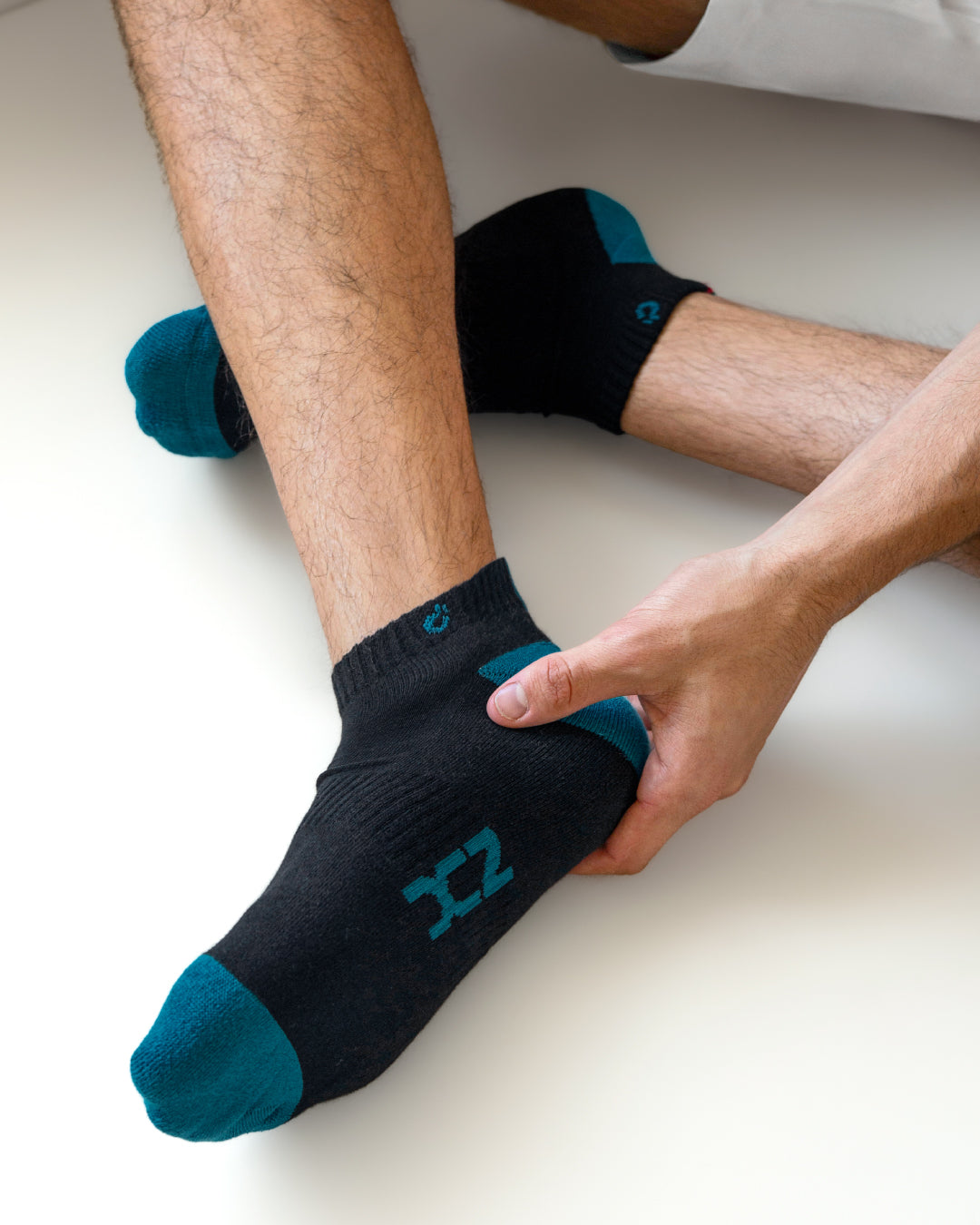 Close-up of DC2 Daily Ankle Socks in black and teal cotton, featuring contrast toe and heel accents with signature logo detailing.