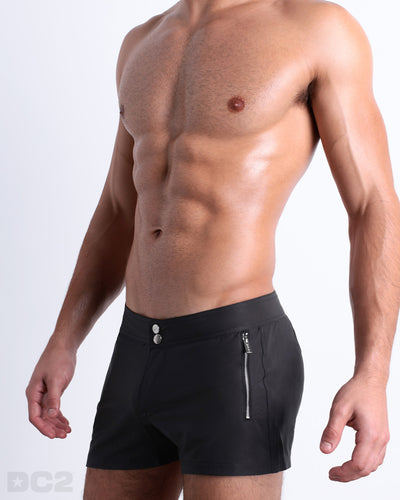Side view of the JET BLACK Summer Beach Shorts with dual zippered pockets for men featuring a solid black color is designed by BANG! Clothes in Miami.
