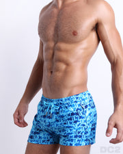 Side view of the WET for men’s beach Poolside Shorts with dual zippered pockets. The shorts have a stylish in a monogram print of the DC2 logo in multiple shades of blue for men for men made by DC2 a brand based in Miami.