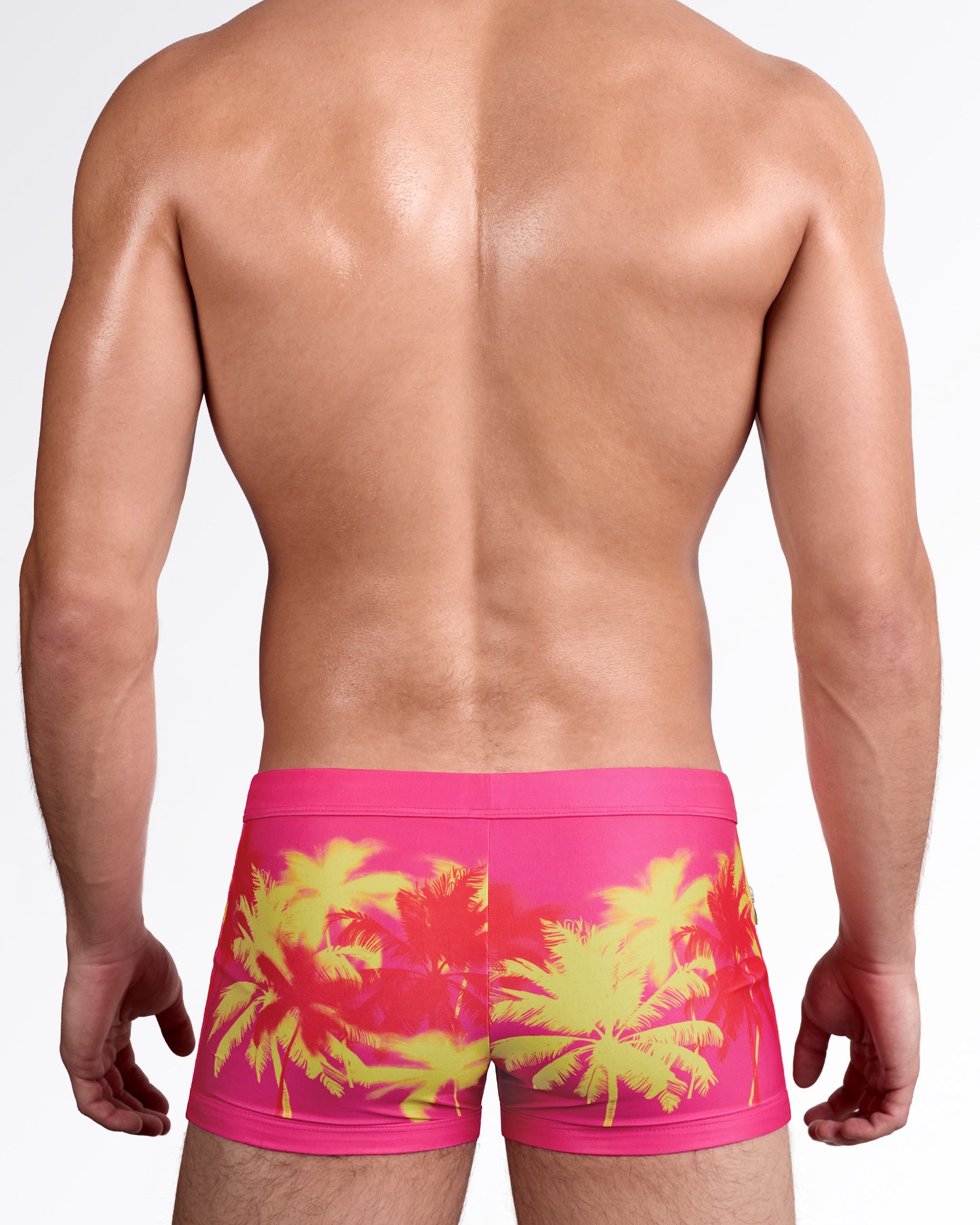 BANG Wuthering Heights Fucsia Swim Trunks — back view showing full wraparound palm tree artwork in high-contrast pink and yellow tones.