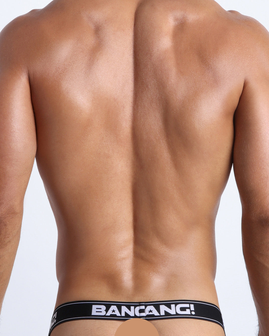 Back view of model wearing the HEY MISTER TJ (CLUB MIX) Men’s beathable cotton jockstrap for men by BANG! with clubbing and disc-jockey details in dark colors. Offers light compression for perfect contouring to the body and second-skin fit.