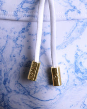 Close-up view of the SPLASH men’s drawstring briefs showing white cord with custom branded golden cord ends, and matching custom eyelet trims in gold.