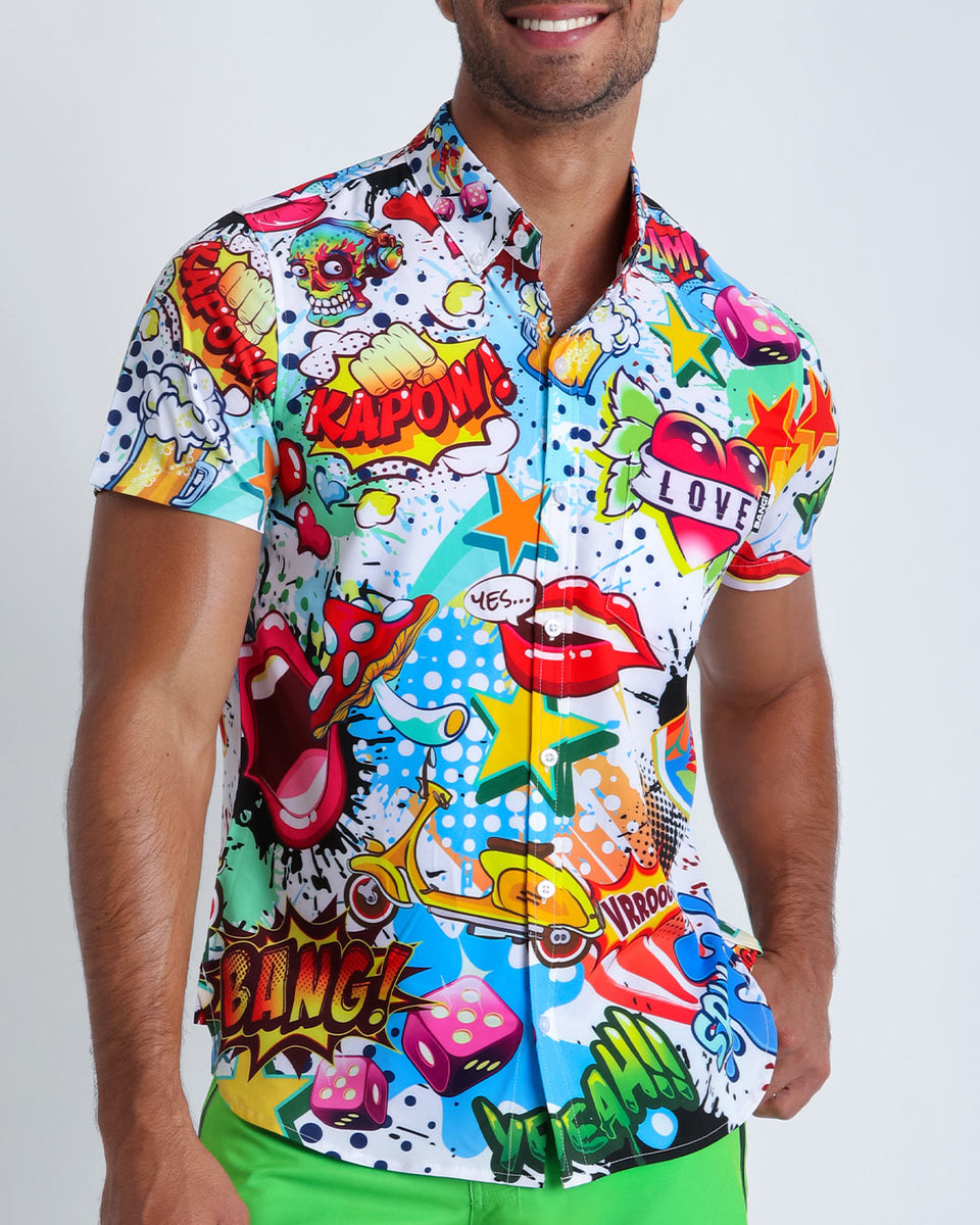 Close up of a man wearing a printed Hawaiian shirt open with black tailored  trousers.