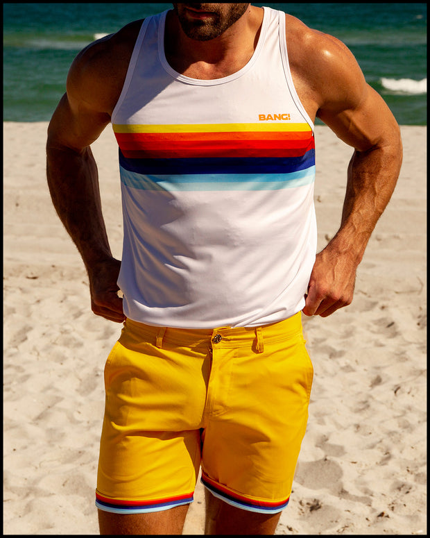 Male model at the beach wearing the MUSTARD ON 45 Street Shorts and the matching STRIPES ON 45 Tank Top by BANG! Clothes.
