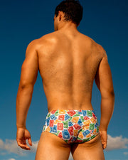 The Via Postal Series of Swimsuits by BANG Miami men beachwear, featuring postage stamps of Miami beach Sun, Fun, Sand, Sea, flamingo, dolphin, jet ski, lifeguard tower.