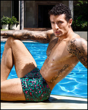 Male model outdoors wearing the CAMO CHAMELEON Swim Trunks by BANG! Clothes the official brand of men’s swimwear.