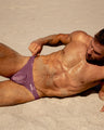 The BUST A MAUVE swimwear series by BANG! Miami, featuring light mauve purple color in all men's swimsuit silhouettes.