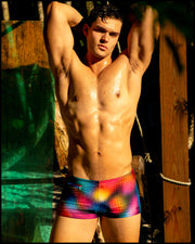 Male model wearing the CONFESSIONA ON A SAND FLOOR Swim Trunks in multiple colors Disco Ball design by BANG! Clothes, the official brand of men’s swimwear.
