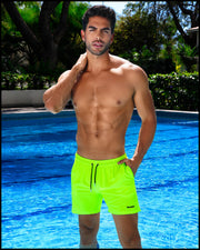 Male model at the pool wearing the ULTRA NEON Resort Shorts by BANG! Clothes is the official brand of men’s swimwear from Miami with premium quality fabrics and bold colors.