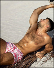 Male model at the beach wearing TOILE DE MIAMI (Red) Show Shorts by BANG! Clothes, showcasing stylish beachwear.