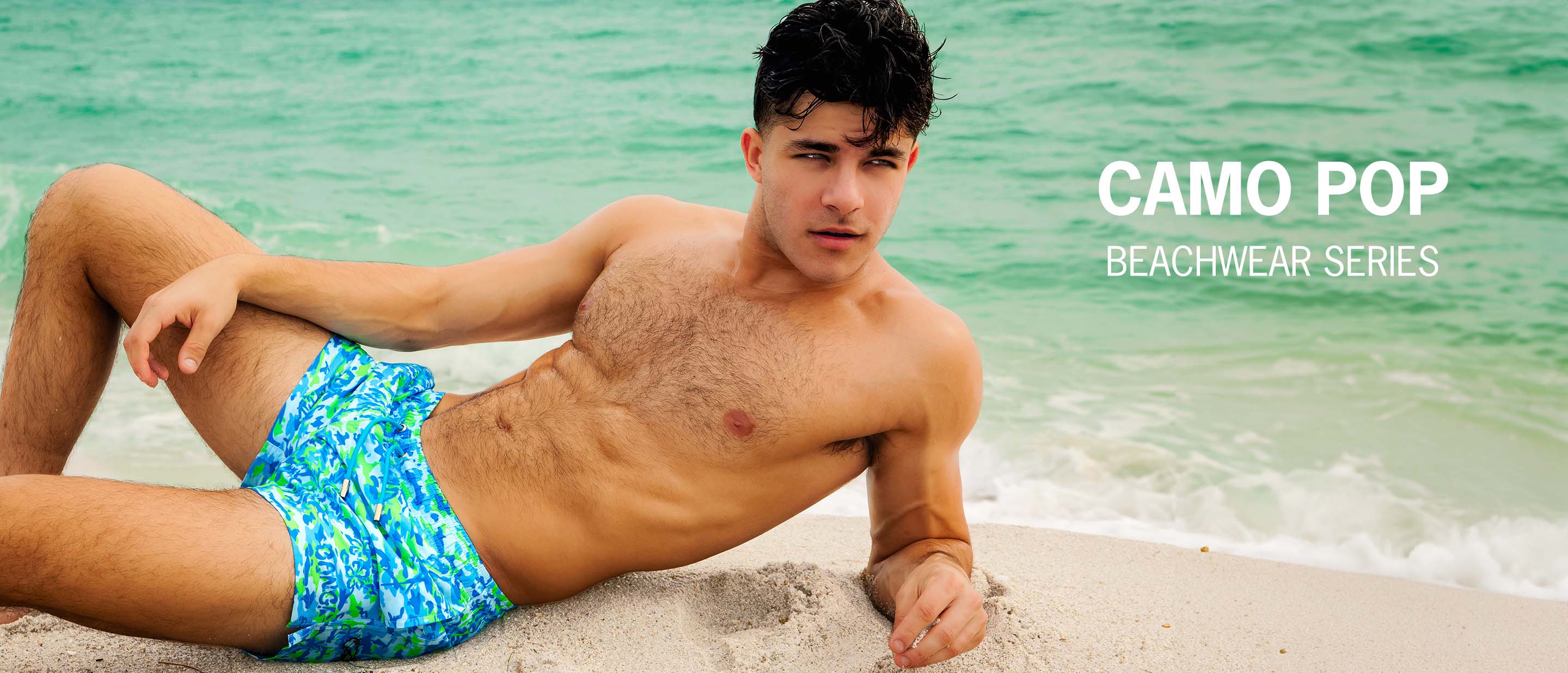 The Camo Chameleon Men's Beachwear Series by BANG! Miami, featuring concealed graphics, hearts, sun, smiley, in green, pink, white and black.