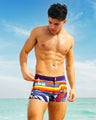 Man wearing the POOL POSITION 
Swim Trunks a vibrant, multicolored swimsuit by BANG! Clothing, featuring bold stripes and graphic patterns. The eye-catching design combines neon hues and abstract shapes, creating a futuristic and energetic look.