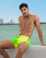 Male model is wearing the SINGLE BILINGUAL (NEON YELLOW/GREEN) Beach Shorts, from BANG! a men’s beachwear brand based in Miami.