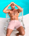 Male model seated by the pool in NAKED PINK Tailored Shorts, a light pink color by the Bang! Menswear brand from Miami.