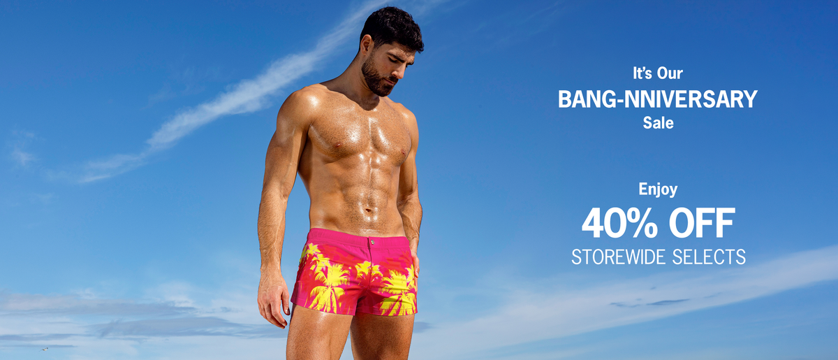 BANG! Miami Anniversary Sale: 40% off storewide selects, featuring a model in vibrant pink palm-print swim shorts against a blue sky.