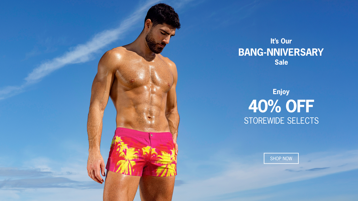 BANG! Miami Anniversary Sale: 40% off storewide selects, featuring a model in vibrant pink palm-print swim shorts against a blue sky.