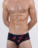 Front view of BANG! 99 Red Balloons Swim Briefs – men's designer swimwear in navy with red numbered balloon print and sleek low-rise cut.
