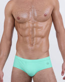 Model wearing AQUA LITE men’s swim briefs in a refreshing seafoam green tone that radiates cool, laid-back summer energy. A sleek and sculpted fit reimagines the classic swim brief cut with an updated silhouette and subtle sophistication.