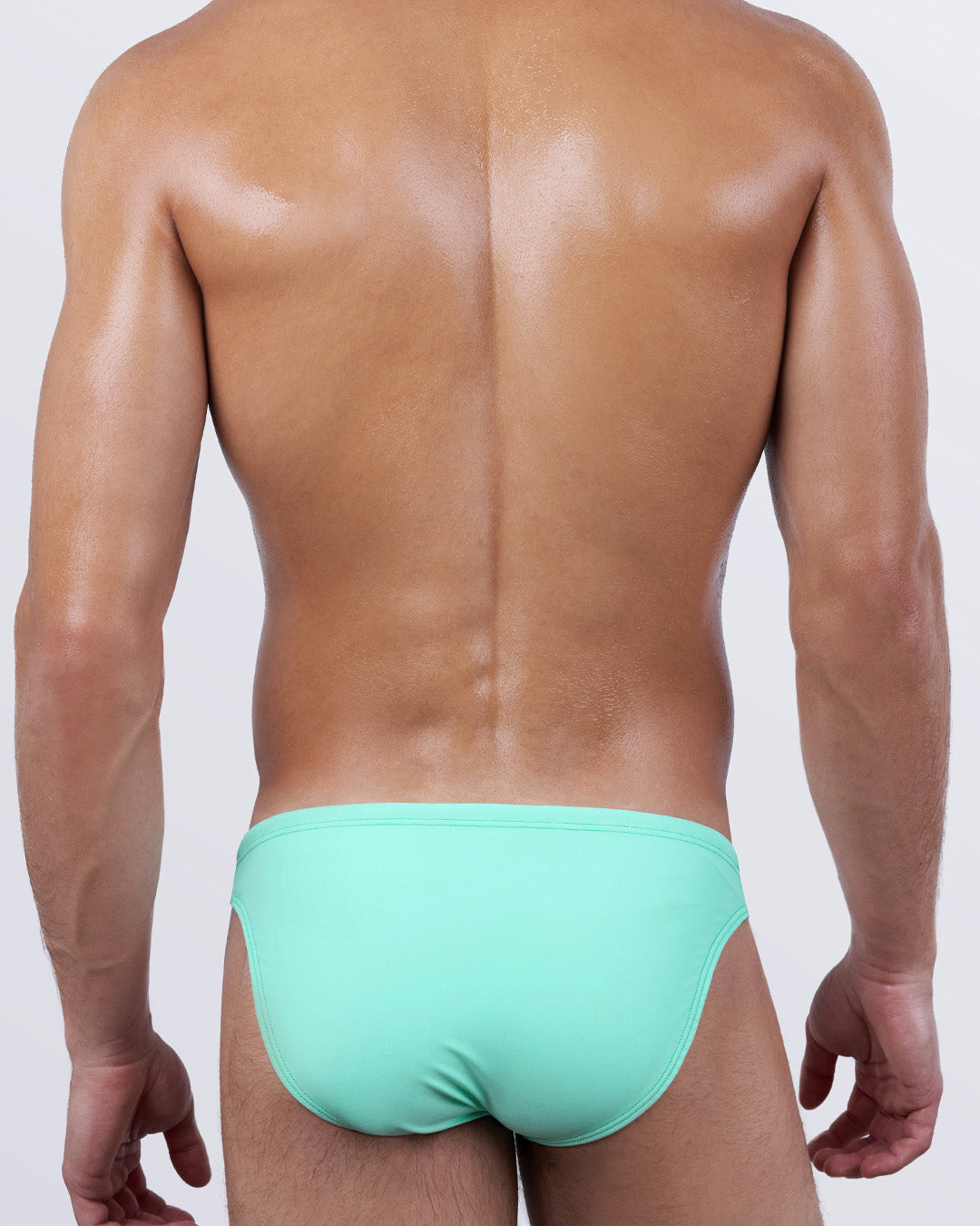 Back view of AQUA LITE men's swim mini briefs, featuring an all-over minty aqua hue. Designer men’s swimwear with a cheeky cut and second-skin fit that hugs the body for a luxe resort-ready finish.