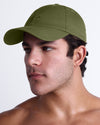 Side angle of DC2 army green resort cap on model, curved brim baseball cap with sleek low-profile fit.
