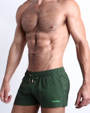 Side view of ALPHA GREEN men’s shorter leg length shorts in army green made by Miami-based Bang Clothing of men's beachwear