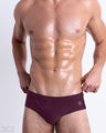 Front view of model wearing the BERRY GOOD men’s Swim Brief in a solid berry red color by DC2, a men's beachwear brand from Miami.