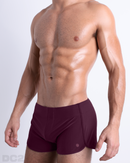 Side view of men’s Summer vintage 80s sprint shorts in BERRY GOOD a solid dark red color made by Miami based Bang capsule brand, DC2.