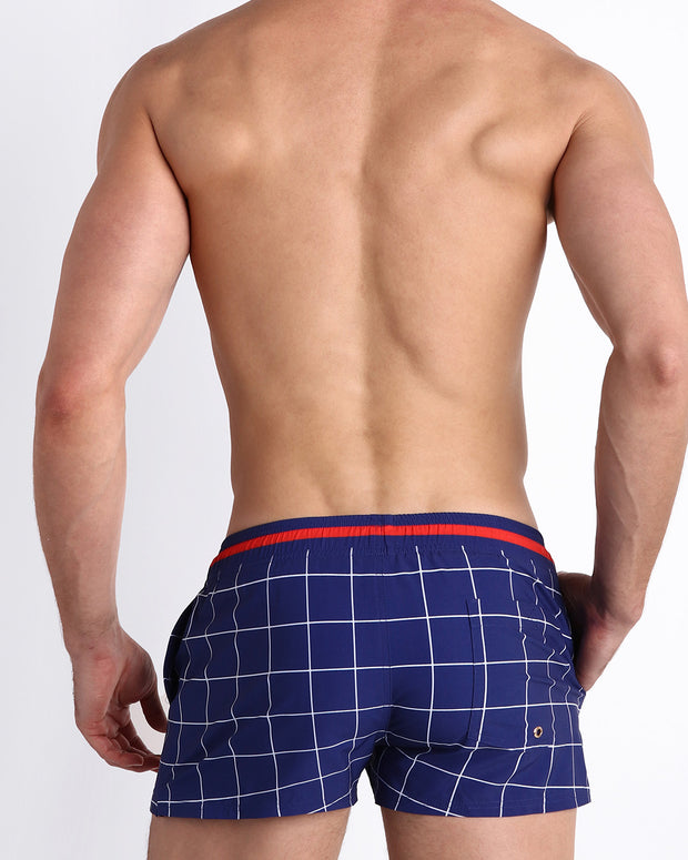 Back view of male model wearing the BJORN AGAIN (FULL BLUE) beach trunks inspired in remixed concept inspired by iconic P.L. Rolando&