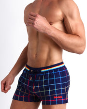 Side view of men’s BJORN THIS WAY (DARK) shorter leg length shorts in navy blue with multi color stripes in red and navy blue made by Miami based Bang brand of men's beachwear.
