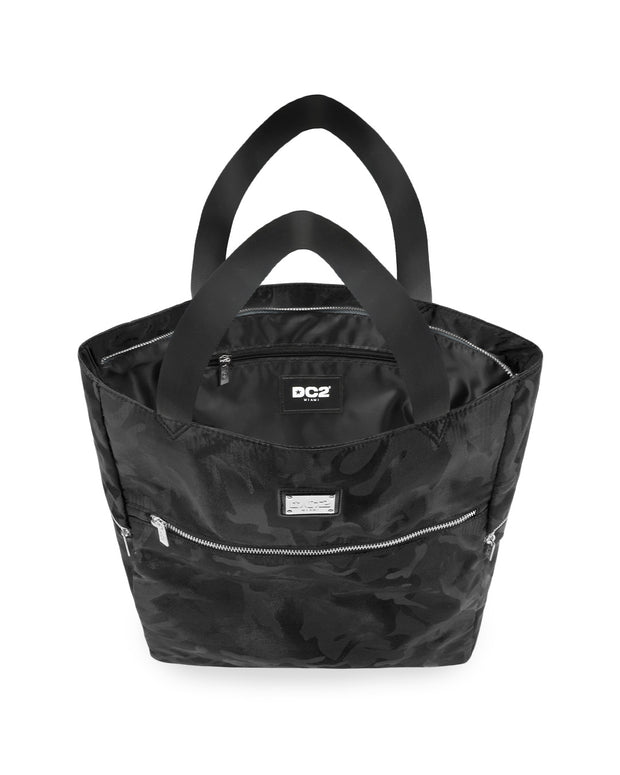 Top view of the BLACK CAMO Poolside Tote Bag by DC2 Miami, showcasing the spacious interior with a visible DC2 Miami logo label. The bag features a black camouflage pattern with sturdy black handles and multiple zippered compartments for secure storage.