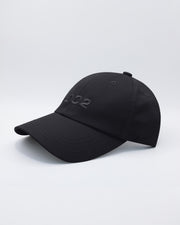 Angled view of the BLACK Chillax Cap, featuring a sleek and minimalist design in solid black. The cap is made from high-quality fabric, with a curved brim and subtle stitched logo from DC2 Miami on the front panel.