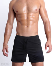 Frontal view of male model wearing the BLACK 2-in-1 Endurance Shorts in a solid black color quick-dry by DC2 brand of men's beachwear from Miami.