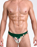 DC2 Bloom Service — model wearing Bloom Service Swim Mini Brief featuring a deep green base with cream panel and tropical lily floral print.