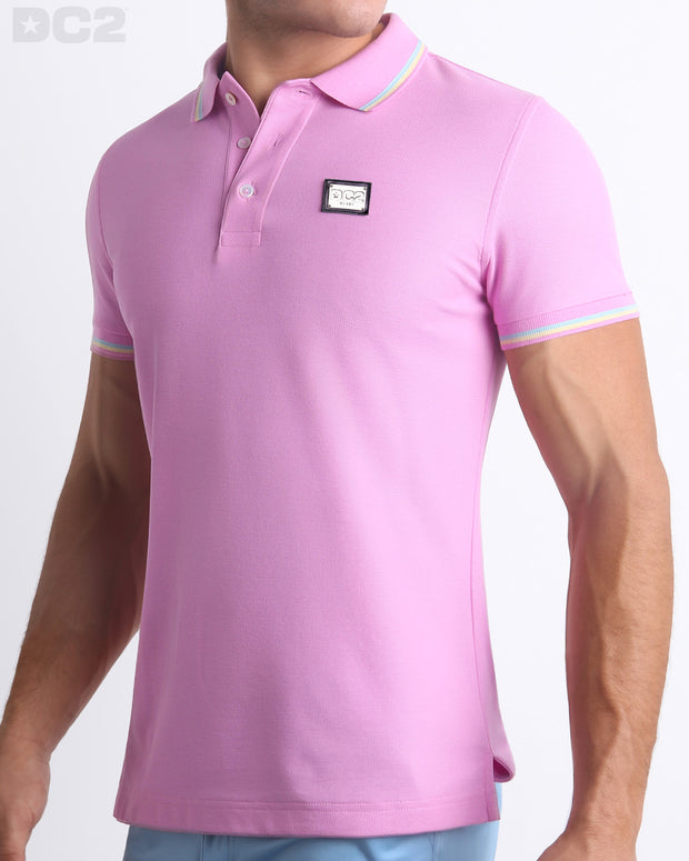 Male model wearing a slim-fitting, BONBON PINK Pima Cotton Polo Shirt by Miami-based DC2. Solid light pink with pastel yellow and aqua stripes on ribbed-knit collar and cuffs.Male model wearing a slim-fitting, BONBON PINK Pima Cotton Polo Shirt by Miami-based DC2. Solid light pink with pastel yellow and light blue stripes on ribbed-knit collar and cuffs.
