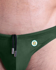 Close-up view of the BRAVE GREEN men’s drawstring briefs showing black cord with custom branded metallic silver cord ends, and custom DC2 logo.