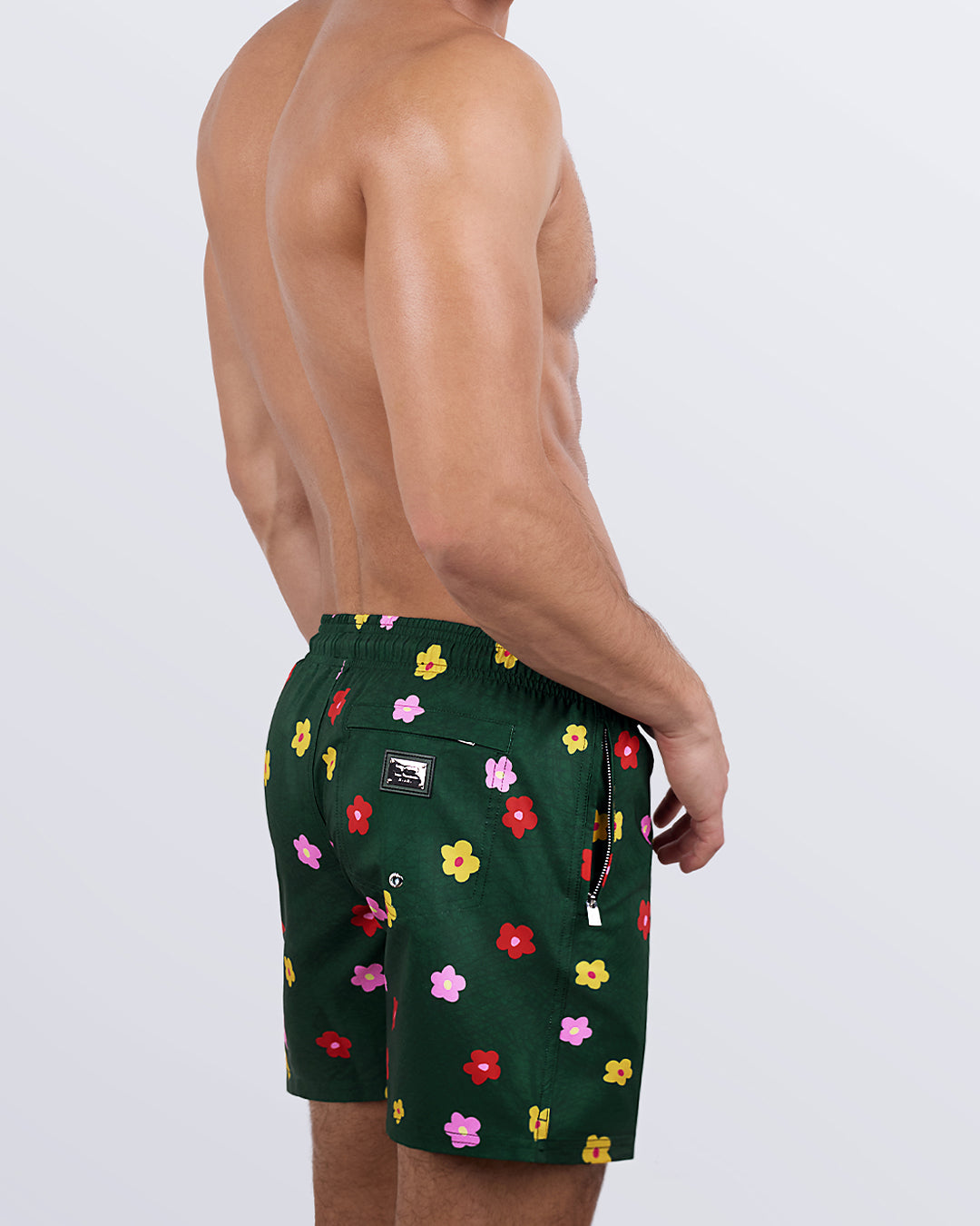 Side view of a male model wearing the BUY MYSELF FLOWERS Resort Shorts for men by DC2 Miami. These swim shorts feature premium four-way stretch fabric, metallic zip pockets for secure storage, and water-resistant technology for all-day comfort.