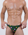 Front view of a male model wearing BUY MYSELF FLOWERS Swim Mini Briefs by DC2 BANG – dark green men's swimwear with colorful floral print, low-rise fit and minimal coverage.