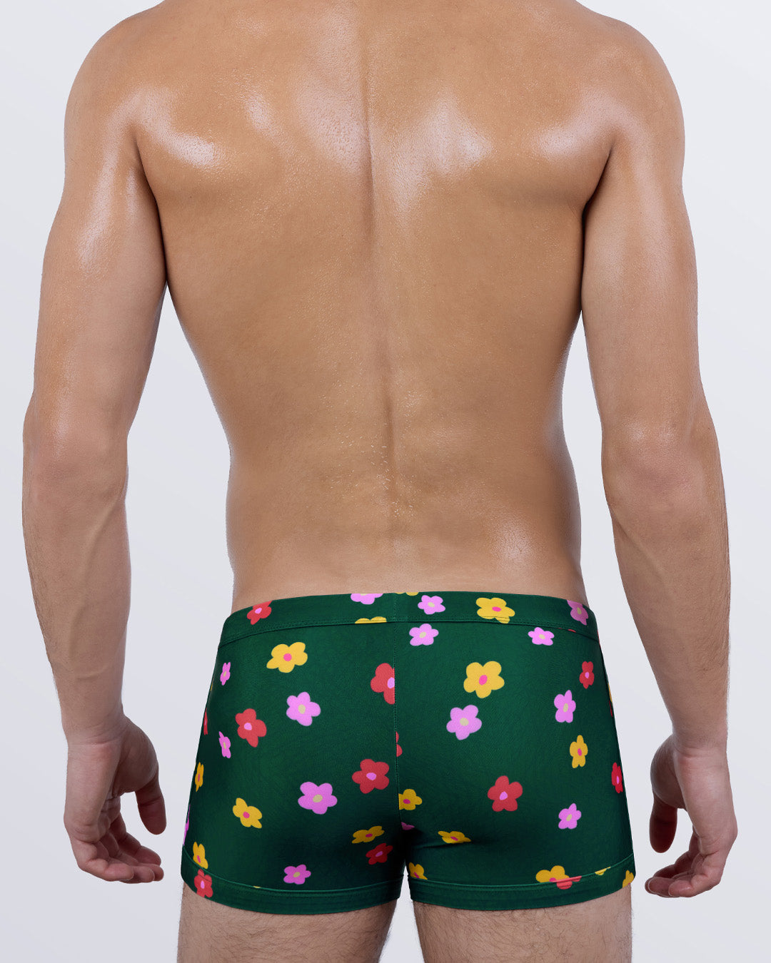 Back view of BUY MYSELF FLOWERS men’s floral swim trunks highlighting snug fit, bold flower pattern across the rear, and sculpted silhouette—designed for tropical getaways and stylish swimwear statements.