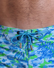 Close-up view of men’s summer Flex shorts by BANG! clothing brand, showing blue color cord with custom-branded golden cord ends, and matching custom eyelet trims in gold.