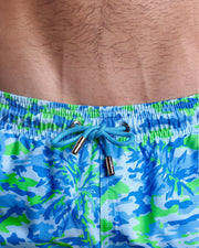 Close-up view of the CAMO POP (BLUE/GREEN) men’s summer shorts, showing sky blue cord with custom branded golden cord ends, and matching custom eyelet trims in gold.