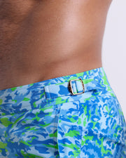 Close-up view of the CAMO POP (BLUE/GREEN) men’s swimwear, showing custom branded golden adjustable side buckles.