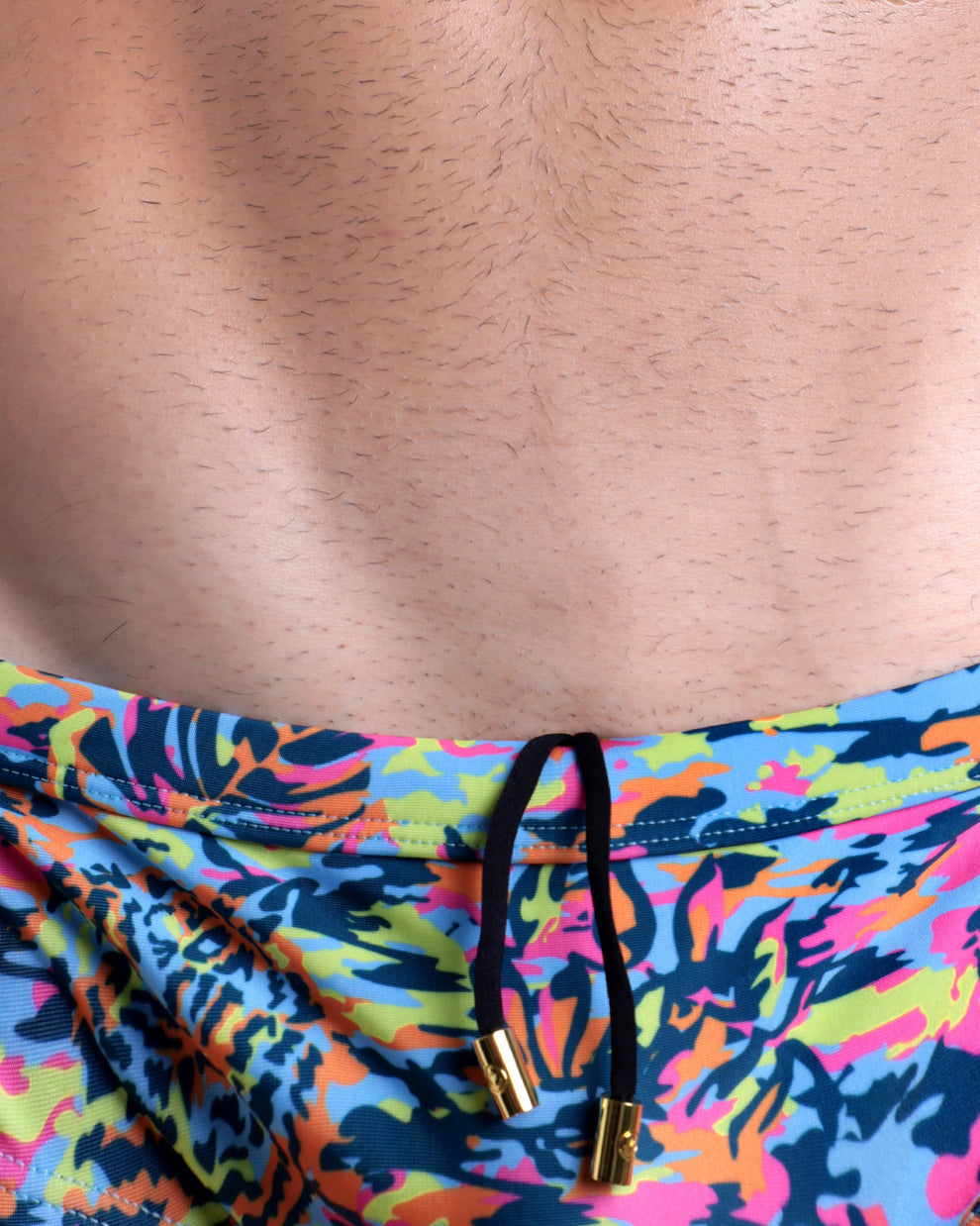 Close-up view of the CAMO POP (COLOR MIX) men’s drawstring briefs showing black cord with custom branded golden cord ends, and matching custom eyelet trims in gold.