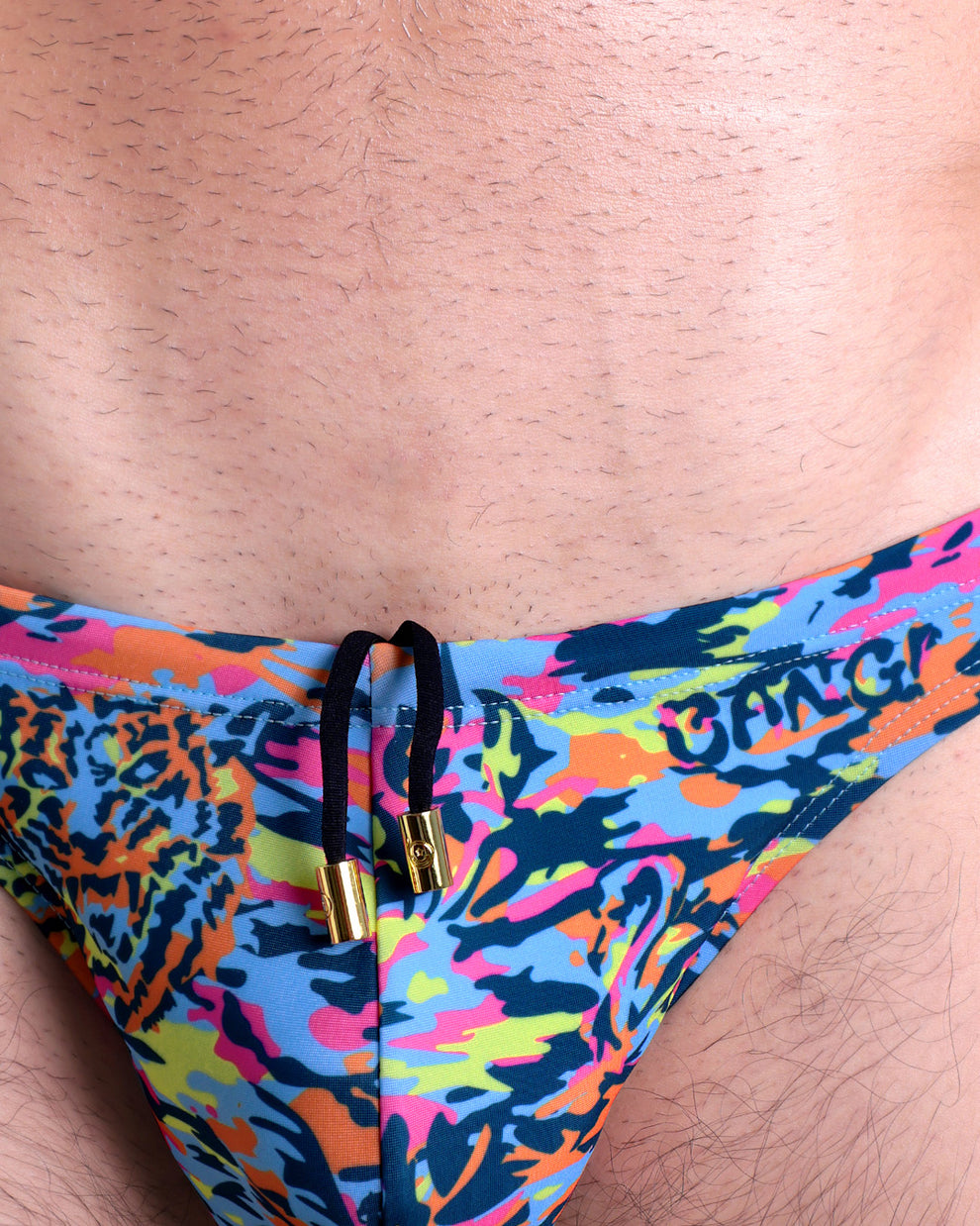 Close-up view of the CAMO POP (COLOR MIX) men’s drawstring briefs showing black cord with custom branded golden cord ends, and matching custom eyelet trims in gold.