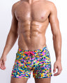 Male model wearing CAMO POP (NEON MIX) Flex Shorts, a multicolor neon print for men. These premium quality swimwear bottoms are by BANG! Clothes, a men’s beachwear brand from Miami.