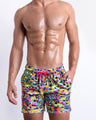 Male model wearing CAMO POP (NEON MIX), a multicolor neon print for men. These premium quality swimwear bottoms are by BANG! Clothes, a men’s beachwear brand from Miami.