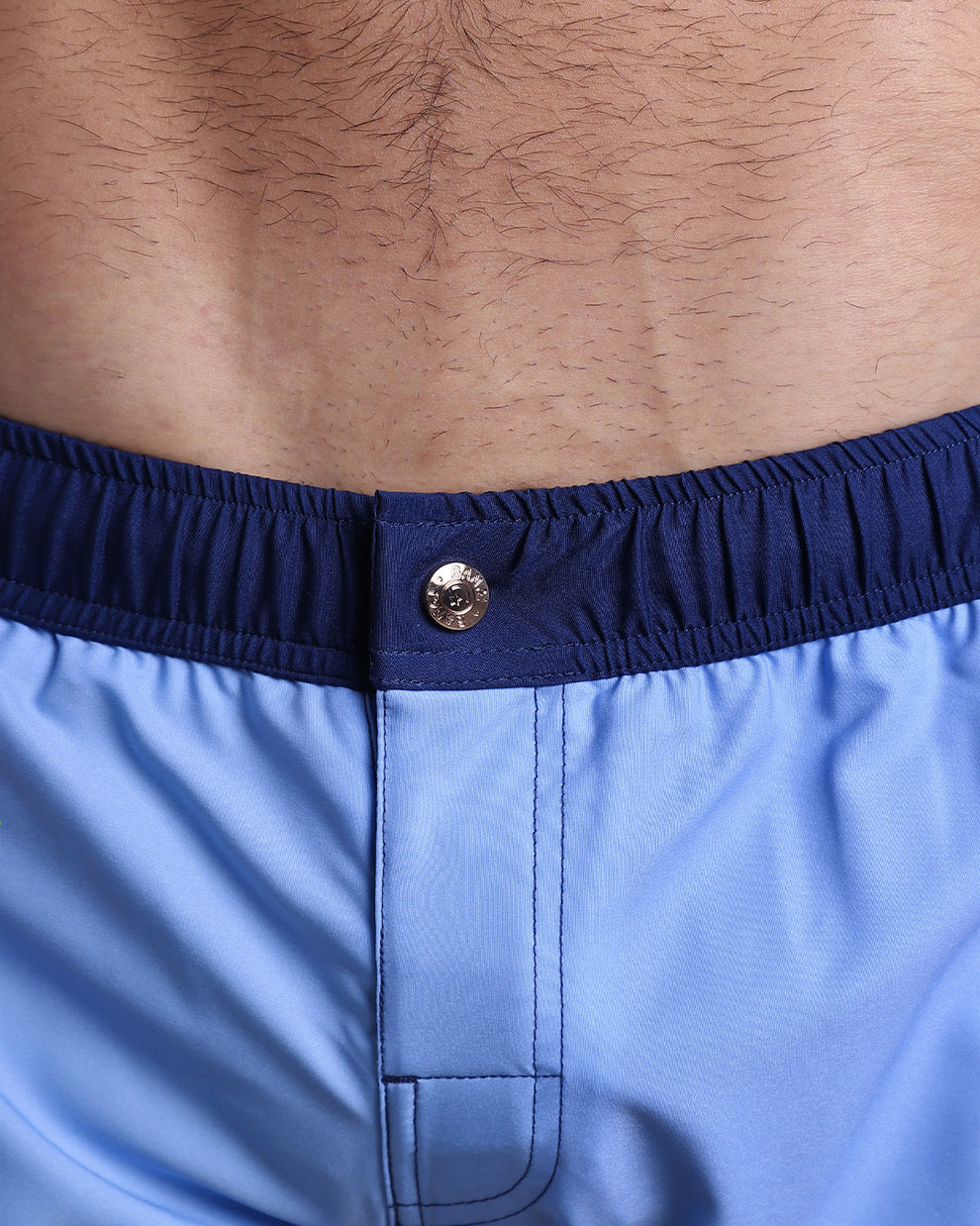 Close-up view of the CASINO ROYALE (BLUE) men’s Mini shorts, showing custom branded metal button in gold by Bang!